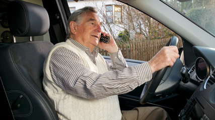 Senior beim telefonieren im Auto