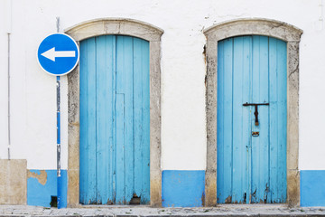 Obraz na płótnie Canvas dwa niebieskie drzwi i niebieski znak drogowy