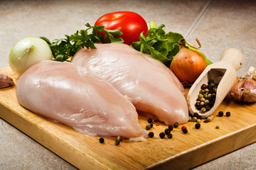 Raw chicken breasts on cutting board