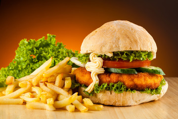 Big hamburger, French fries and vegetables