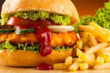 Big hamburger, French fries and vegetables