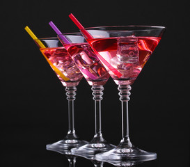 Red cocktail in martini glasses isolated on black