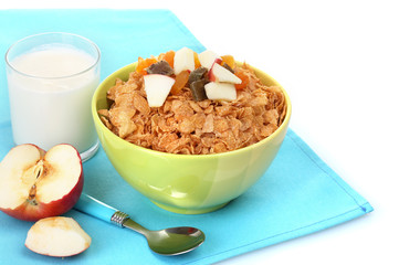 tasty cornflakes in bowl with dried fruits, glass of milk and