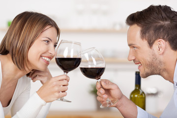 glückliches paar stößt mit einem glas wein an