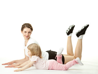 Young woman doing sport exercises with her little daughter