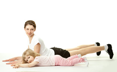Happy mother doing sport exercises with her little daughter