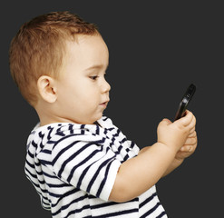 portrait of funny kid touching mobile over black background
