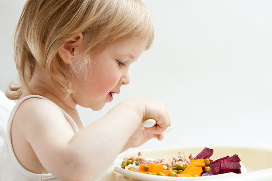 Adorable Baby Girl Eating Fresh Vegetables