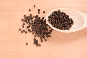 black pepper with spoon on the wooden cutting board