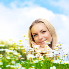 Beautiful woman enjoying daisy field and blue sky