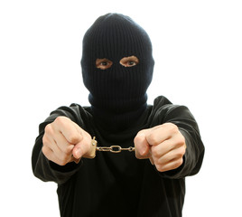Bandit in black mask handcuffed isolated on white