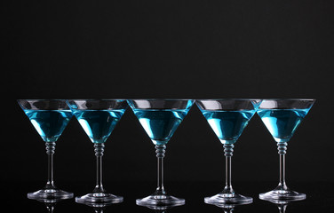 Blue cocktail in martini glasses isolated on black
