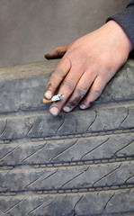 Hand with cigarette and old tire, smoking issues