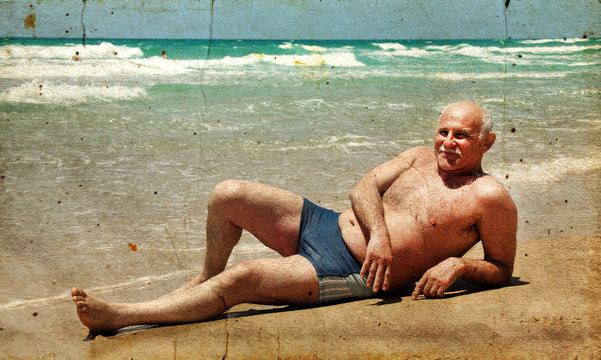 60-year-old Man Lying On The Sand At The Beach