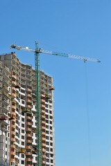 Fototapeta na wymiar Budowa d¼wigu i budynku w trakcie budowy z błękitnego nieba