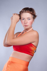 Obraz premium young woman in an orange suit. beads around his neck