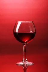 Fotobehang Wineglass on red background © Africa Studio