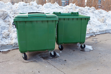 Two green recycling containers in winter park