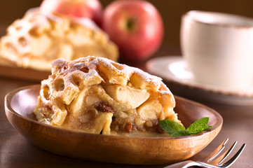 Apple strudel with raisins with coffee cup in back