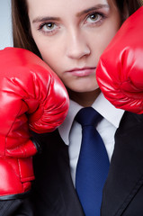 Young businesswoman in boxing concept