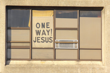 A one way Jesus sign in a window
