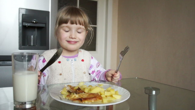 3 years old girl learns to use a knife and fork
