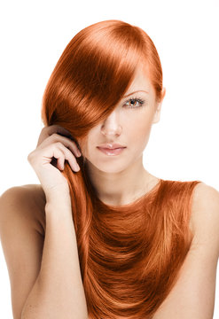 beautiful young woman holding her elegant long red shiny hair