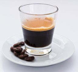 hot espresso coffee with coffee beans on a small plate