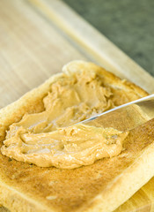 spreading peanut butter on toast
