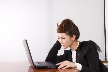 busy work, dress-up female model officer working with laptop.