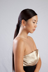 Obraz premium Pretty Asian woman with bare shoulders looking to right