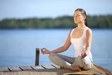 Fototapete beautiful young girl training yoga near a lake © Vladimir Badaev