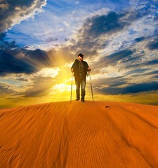 hiker on a sand dune at the sunset