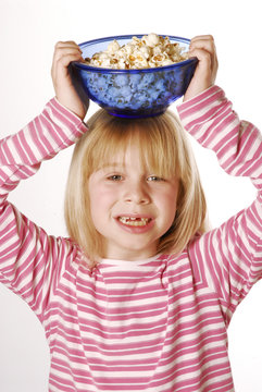 Niña comiendo palomitas de maíz.