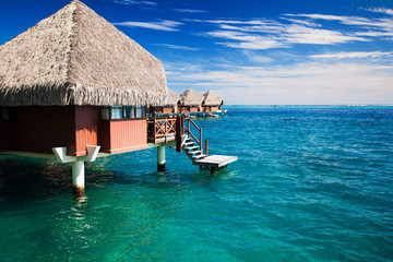 Over water bungalow with steps into clear ocean