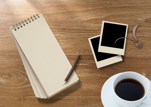 wood background with notebook and photo frame