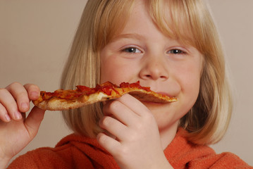 Niña feliz comiendo pizza,comida rápida.