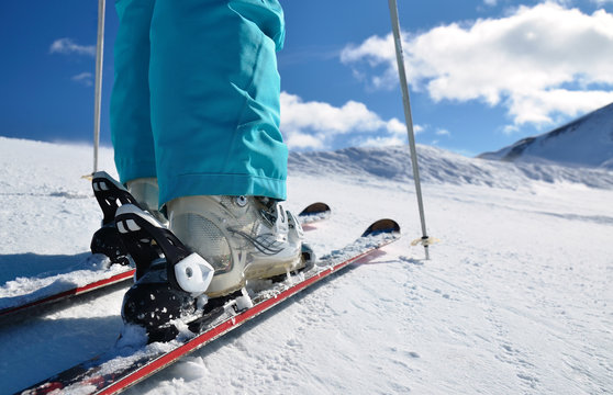 woman's legs in ski boots, standing on skis