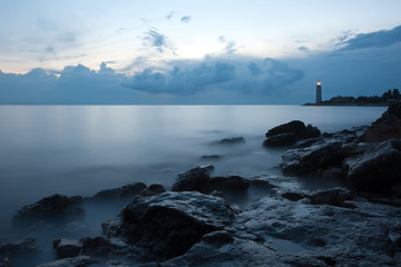 Nightly seascape with lighthouse and moody sky