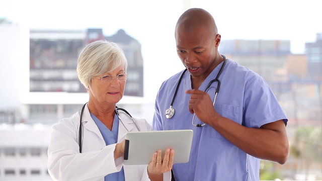 Happy doctor and nurse looking at a tablet pc