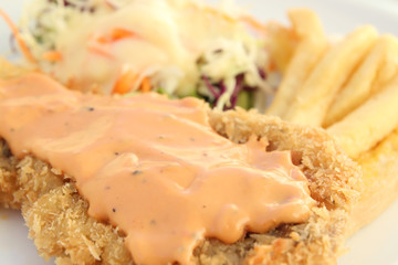 fried breaded fish steak with gravy topping