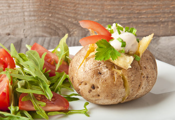 Baked potato filled with sour cream and arugula