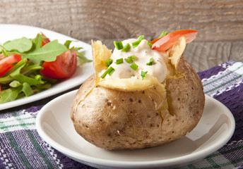 Baked potato filled with sour cream and arugula