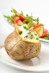 Baked potato filled with sour cream and arugula
