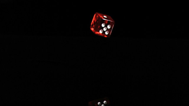 One red translucent dice in a super slow motion turning