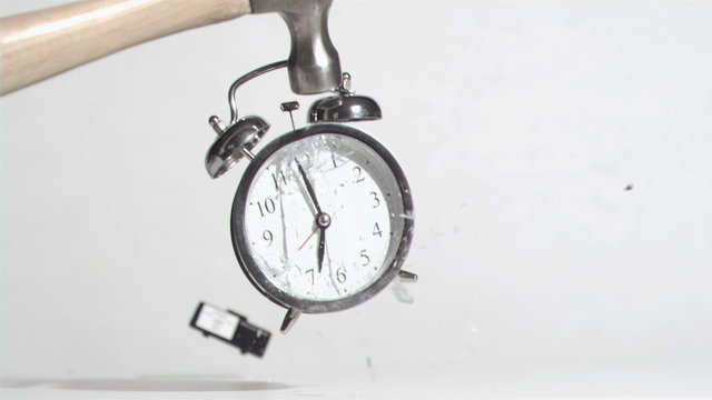 Alarm clock sounds in a super slow motion crushing by a hammer