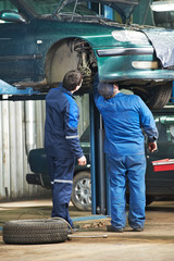 two car mechanic diagnosing auto suspension