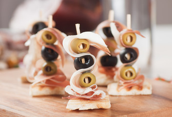 Canape with pickled olives and prosciutto