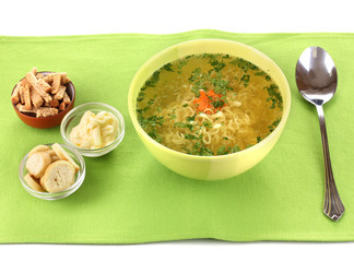 Tasty chicken stock with noodles on green tablecloth