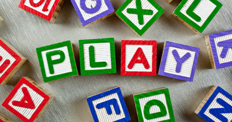 Wooden blocks forming the word PLAY in the center